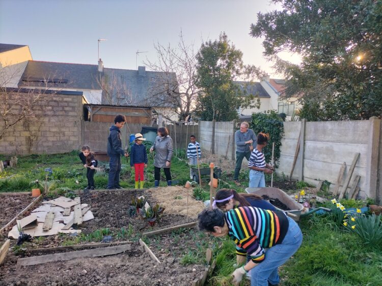 Groupe d'enfants avec bénévoles en train de jardiner